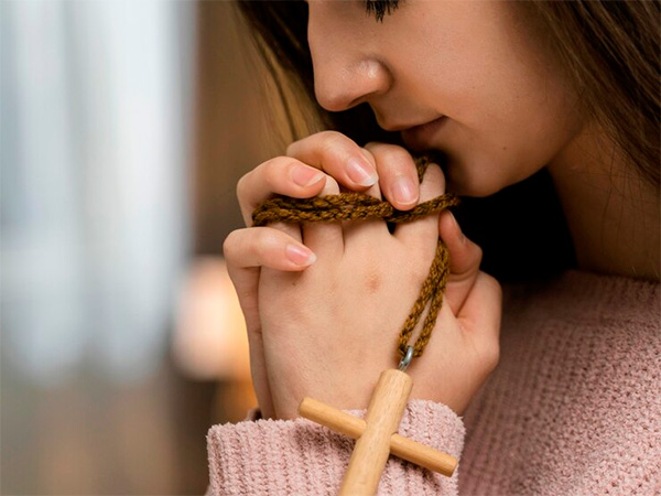 Mulher orando o Creio em Deus Pai (também conhecida como a Oração do Credo)